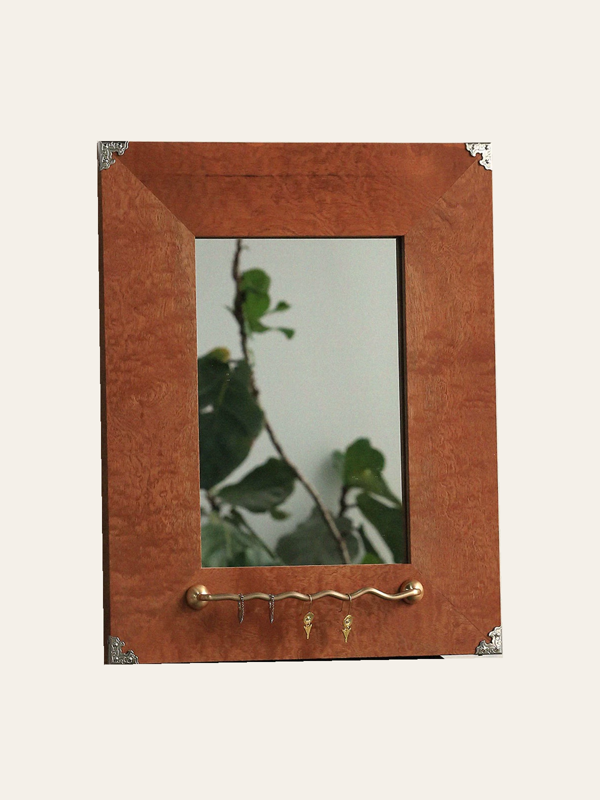 Reddish brown wood jewelry mirror with silver tone corners and gold tone wavy rail