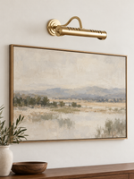 Copper-tone picture light above artwork, unlit