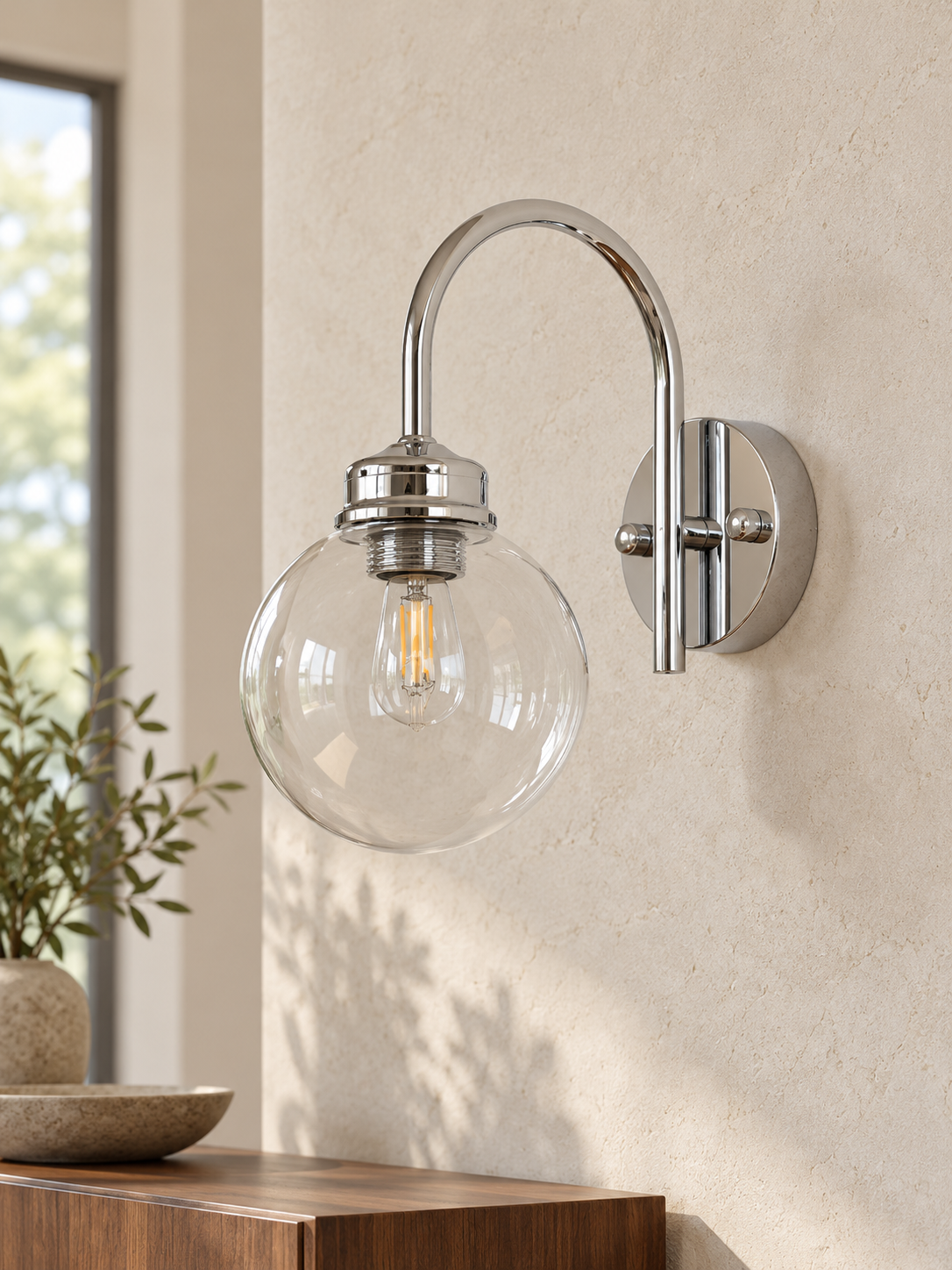 Curved-Arm Glass Globe Wall Sconce, 220–240V — Chrome / Clear — unlit interior scene