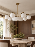Copper-tone sculpted glass chandelier with white glass shades in a dining room