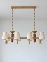 8-light linear chandelier, straight-on product view, unlit pleated fabric shades and copper-color hardware