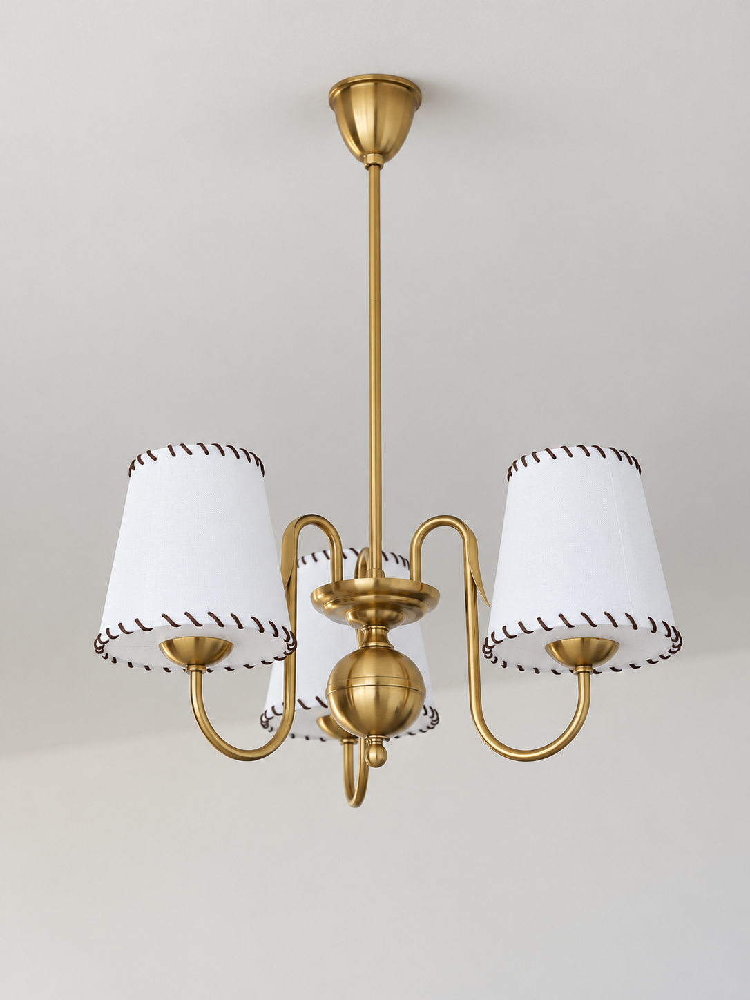 Copper-tone chandelier with 3 white stitched fabric shades, shown unlit, product view