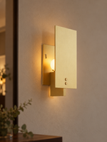 Panel Glow Copper Tone wall sconce illuminated in an evening interior