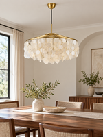 Gold A Round 60 cm shell-disc chandelier above a dining table