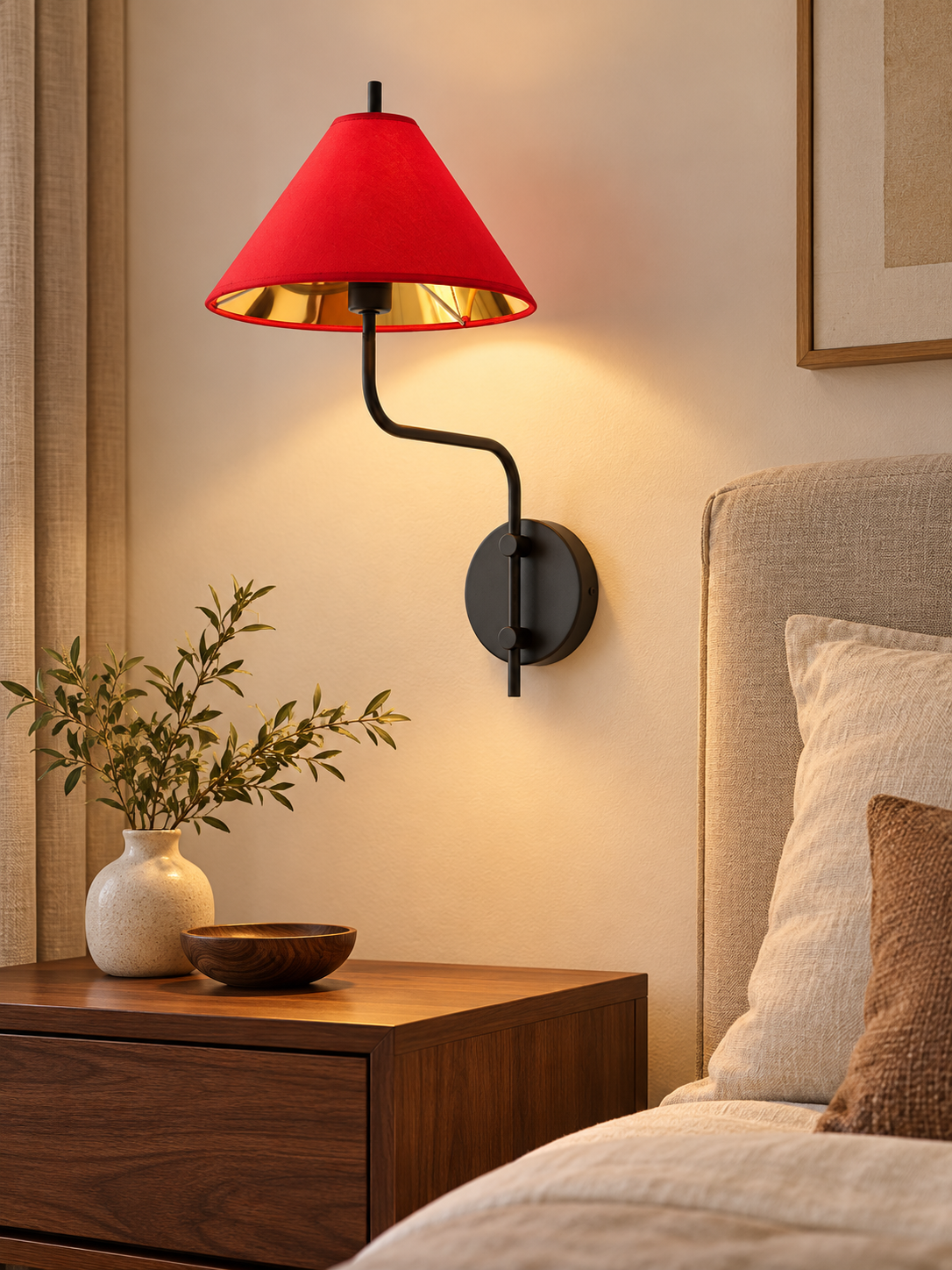 Black and red fabric-shade wall sconce beside a bed