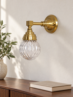 Copper-tone diamond-globe wall light with clear glass in an interior setting