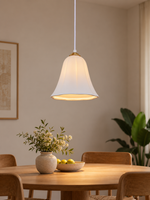 Copper-tone ceramic lily pendant above dining table