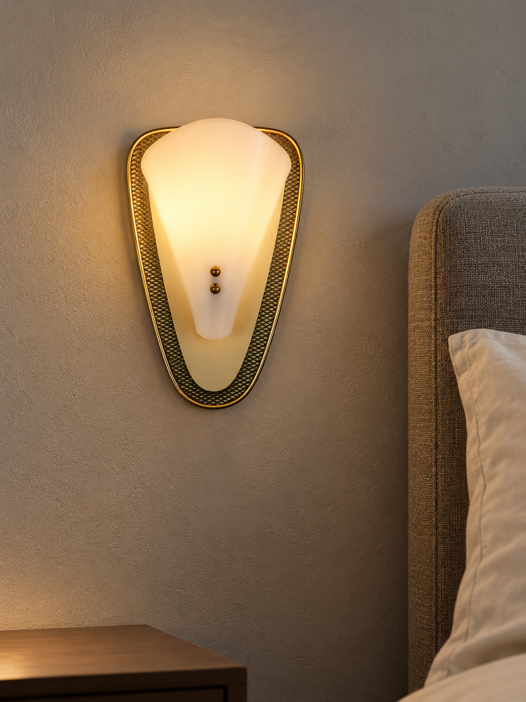 Luma Arc wall sconce illuminated in a styled bedside setting