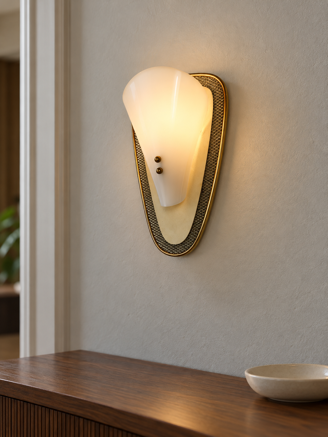 Luma Arc wall sconce illuminated above a console in a styled interior