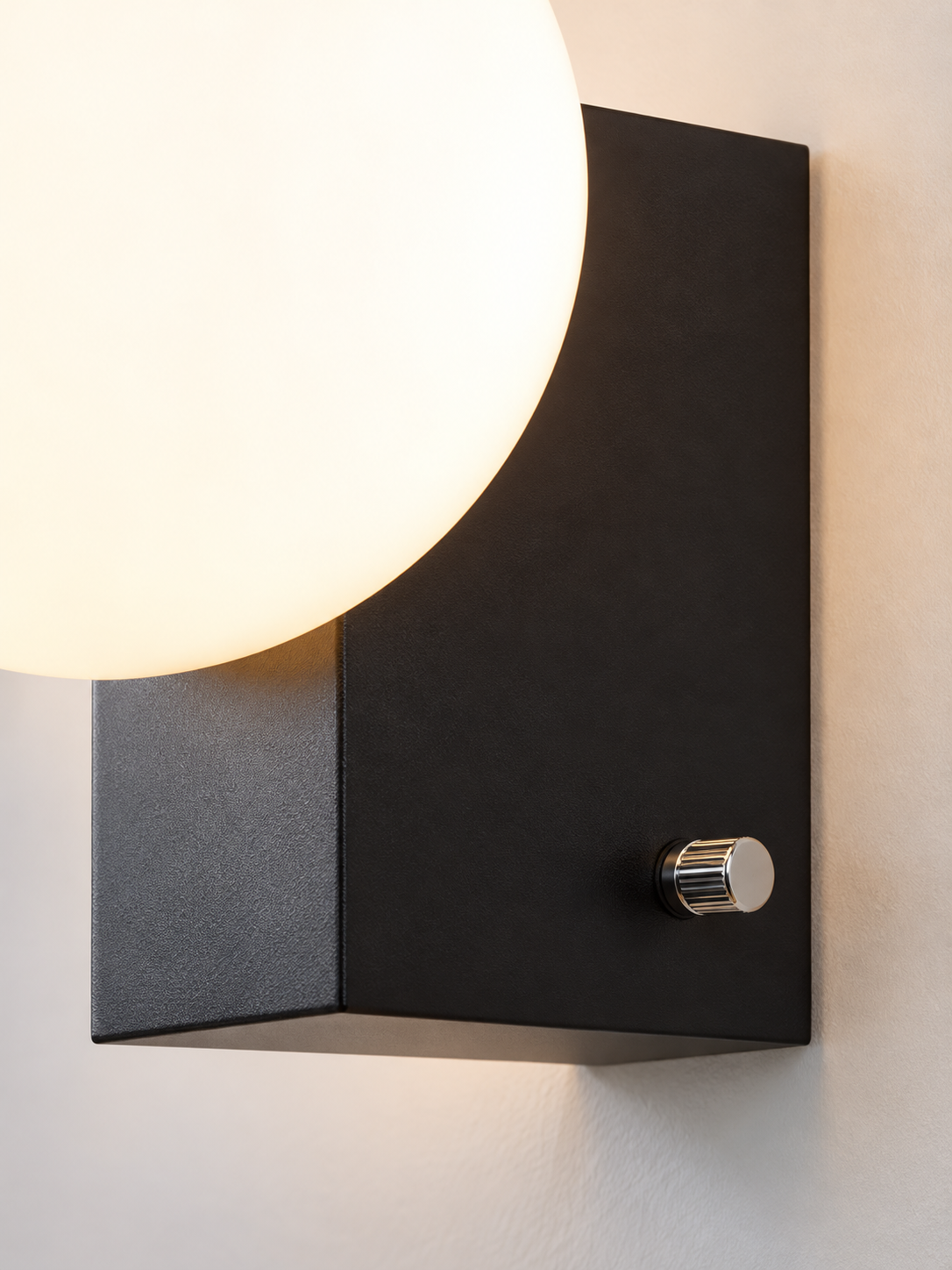 Close detail of black folded metal body and chrome rotary switch