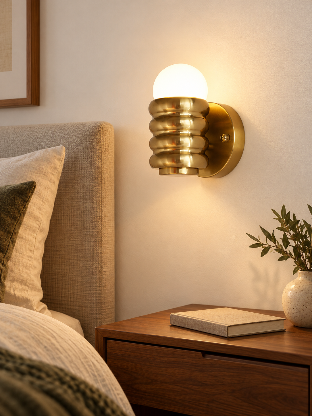 Copper-tone ribbed iron wall light above a walnut bedside table