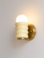 Cream and copper-tone rounded rib iron wall light with globe bulb