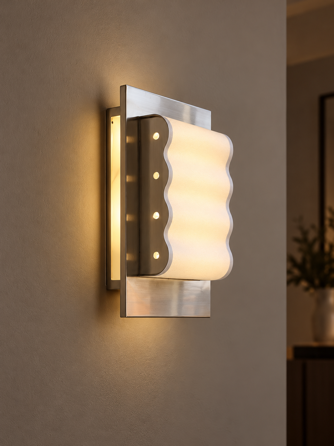 Wave Frame paper wall sconce glowing on a taupe wall at evening