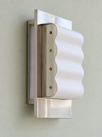 Three-quarter view of the white paper waves, chrome frame and shallow wall mounting