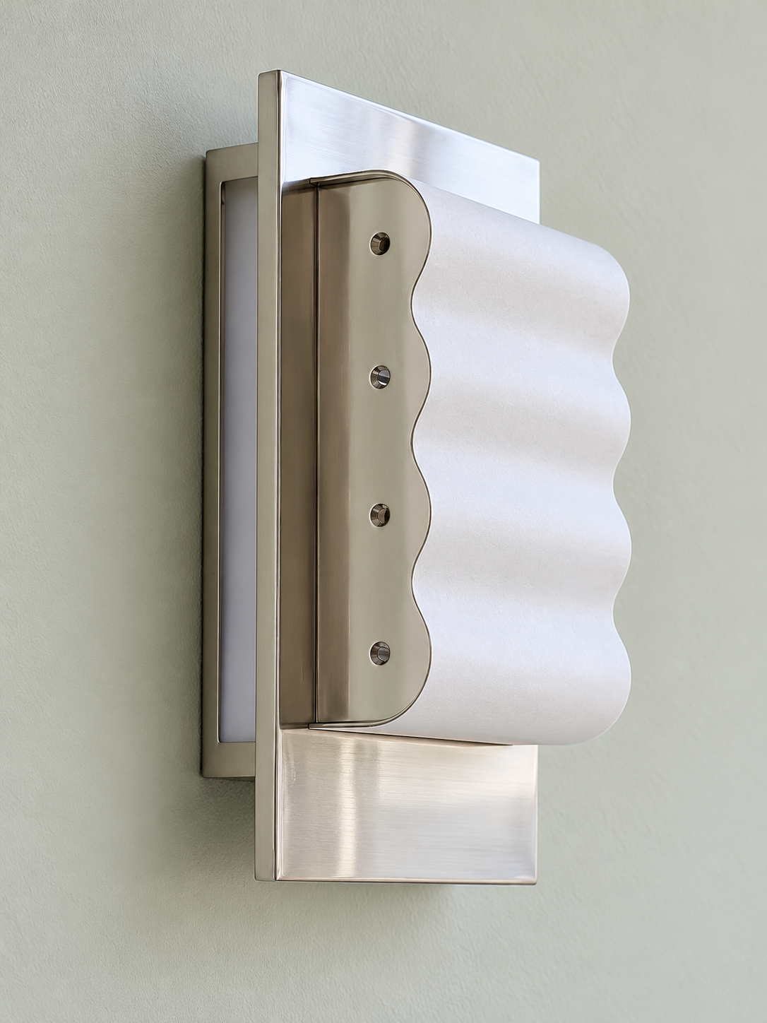 Three-quarter view of the white paper waves, chrome frame and shallow wall mounting
