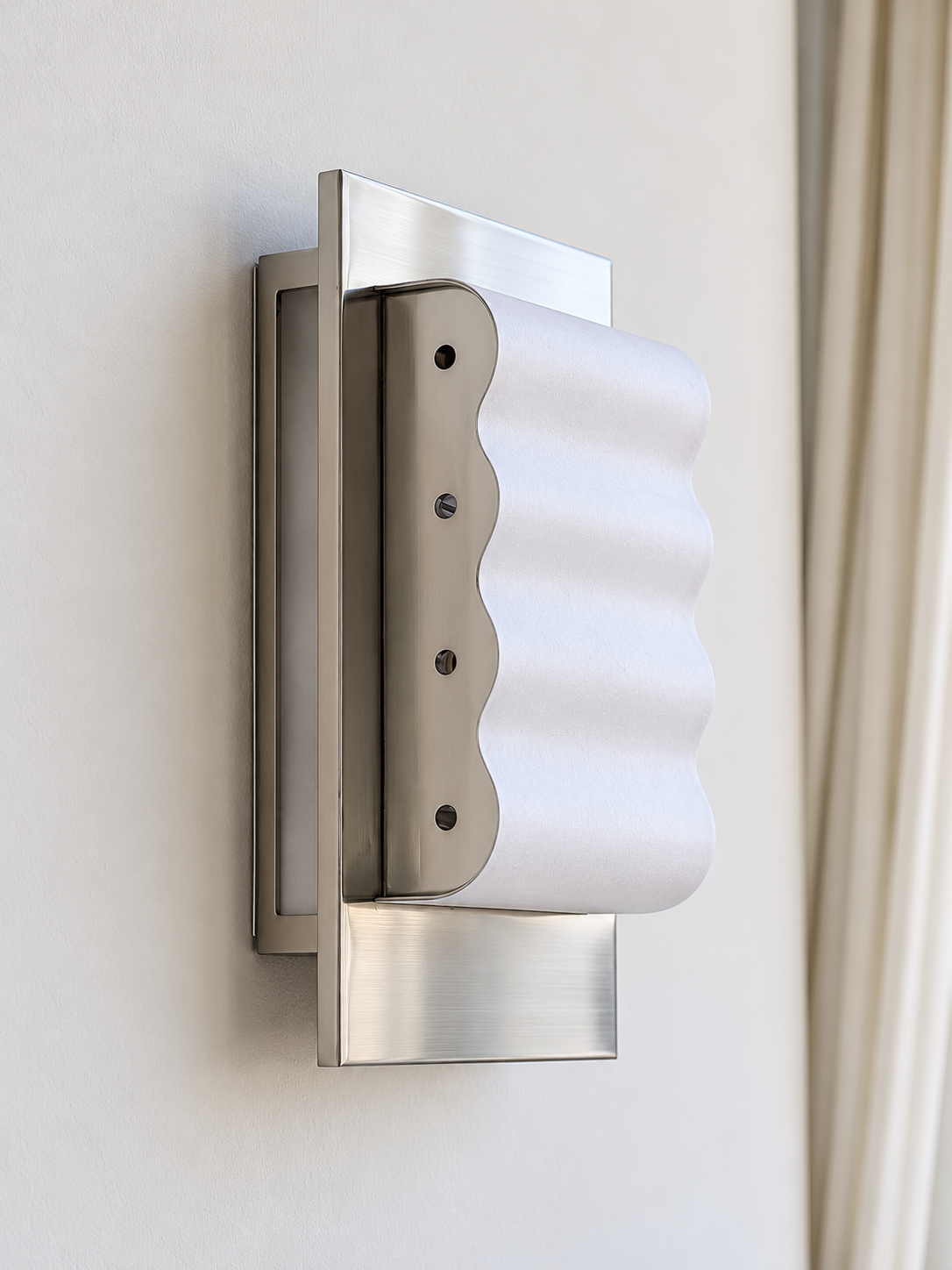 Detail of white paper waves and the chrome side panel with four small circular openings