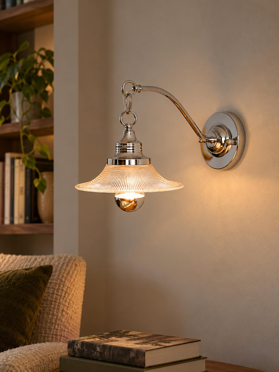 Clear Arc wall sconce casting warm light in a quiet reading alcove