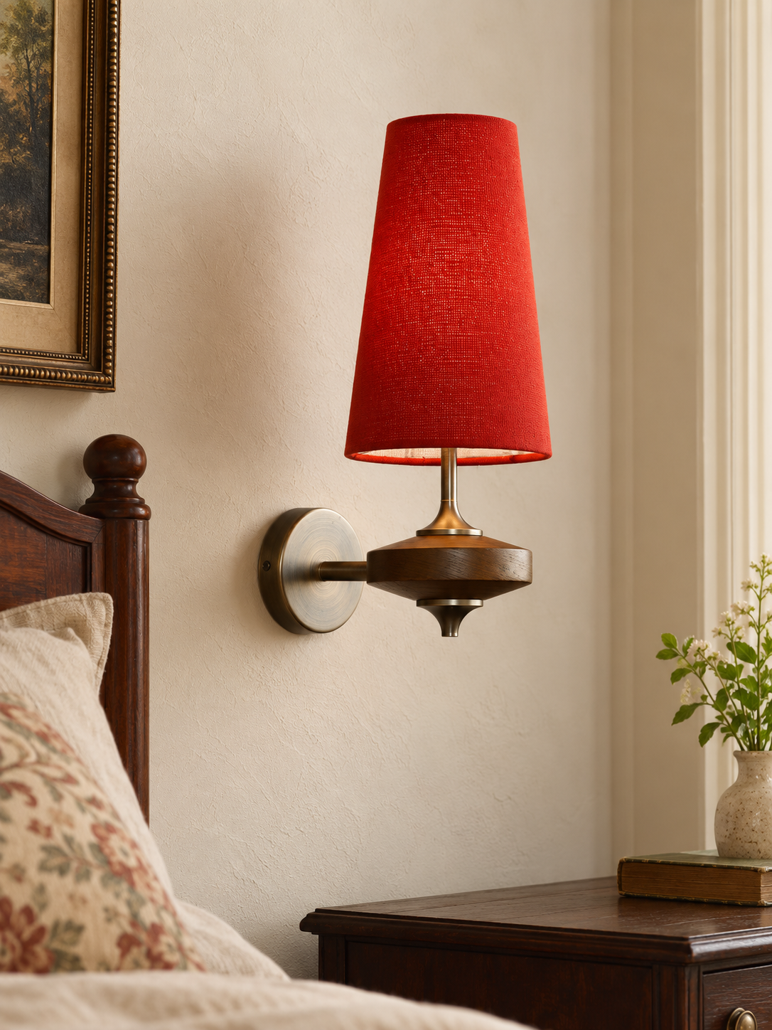 Red tapered fabric wall sconce with brown wood and metal body in a bedroom