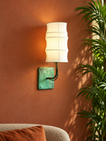 Patinated copper and white fabric wall sconce in a warm living room