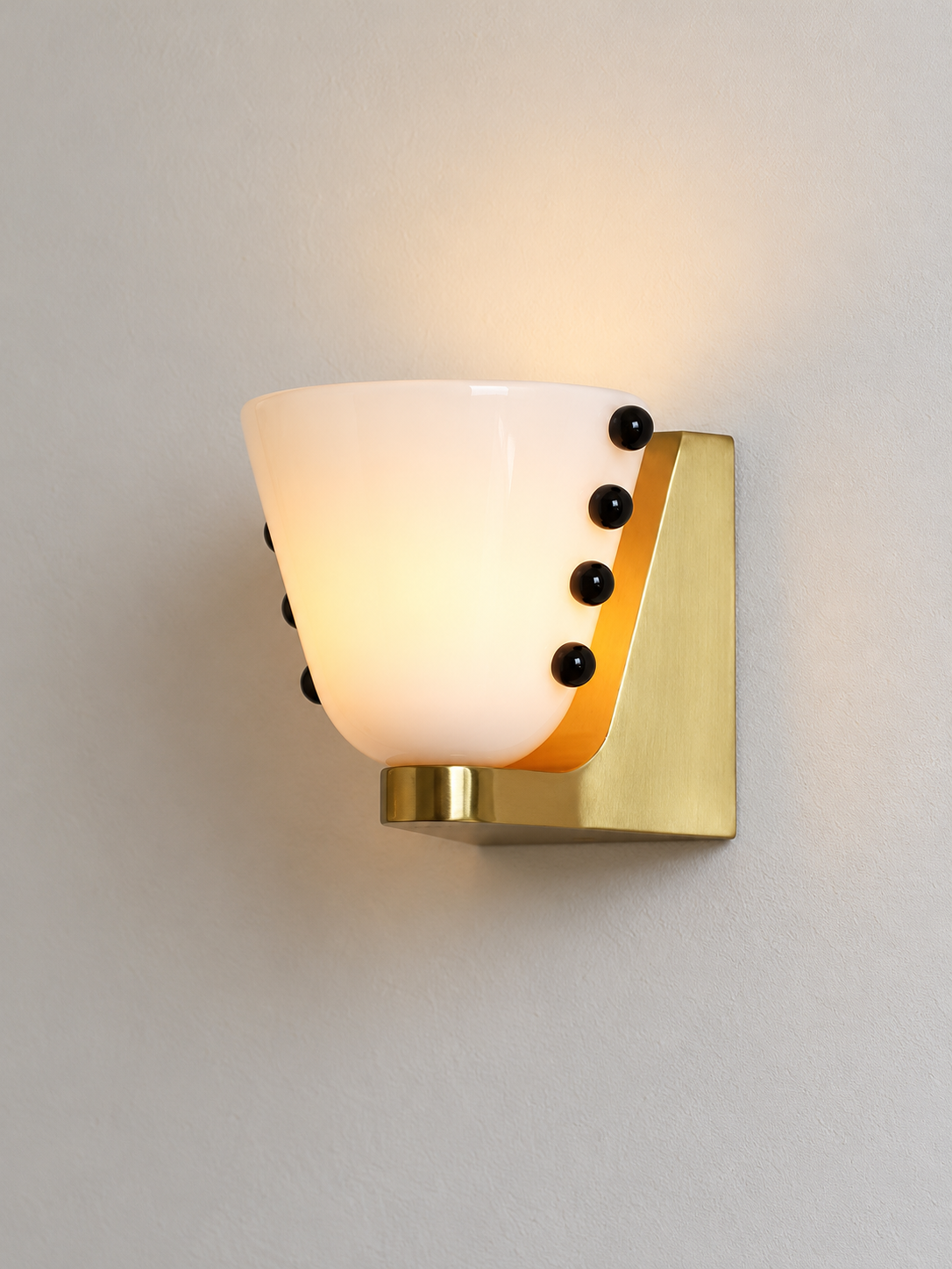 White glass cup wall light with black bead details and copper-tone mount