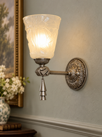 Antique-silver etched glass medallion wall sconce with metal drop ornament, shade facing up