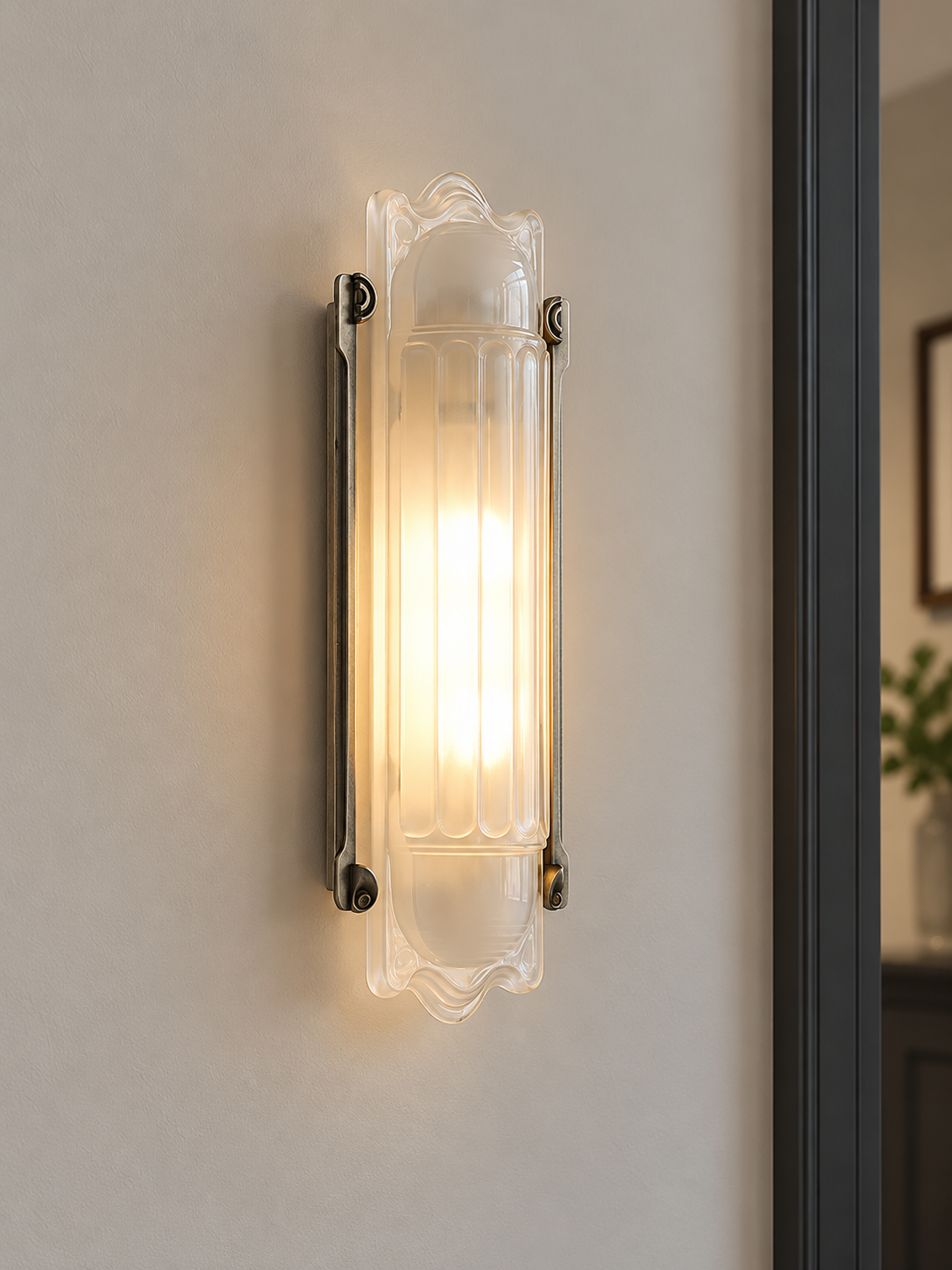 Scroll Edge wall sconce with antique-silver rails and softly lit pressed glass