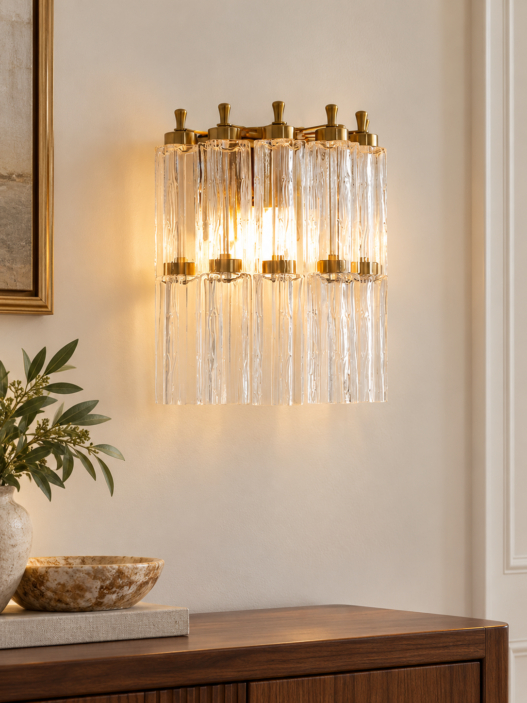 Fluted Glass Column Wall Sconce in Clear glass with copper-tone hardware, illuminated above a walnut console