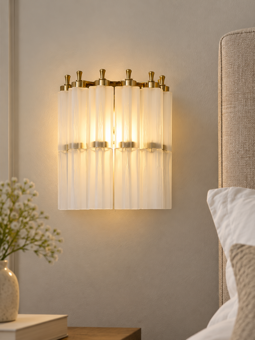 Fluted Glass Column Wall Sconce in Frosted White beside a linen bedroom headboard