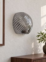 Spiral glass wall sconce in Smoke Gray with chrome hardware, shown unlit in daylight