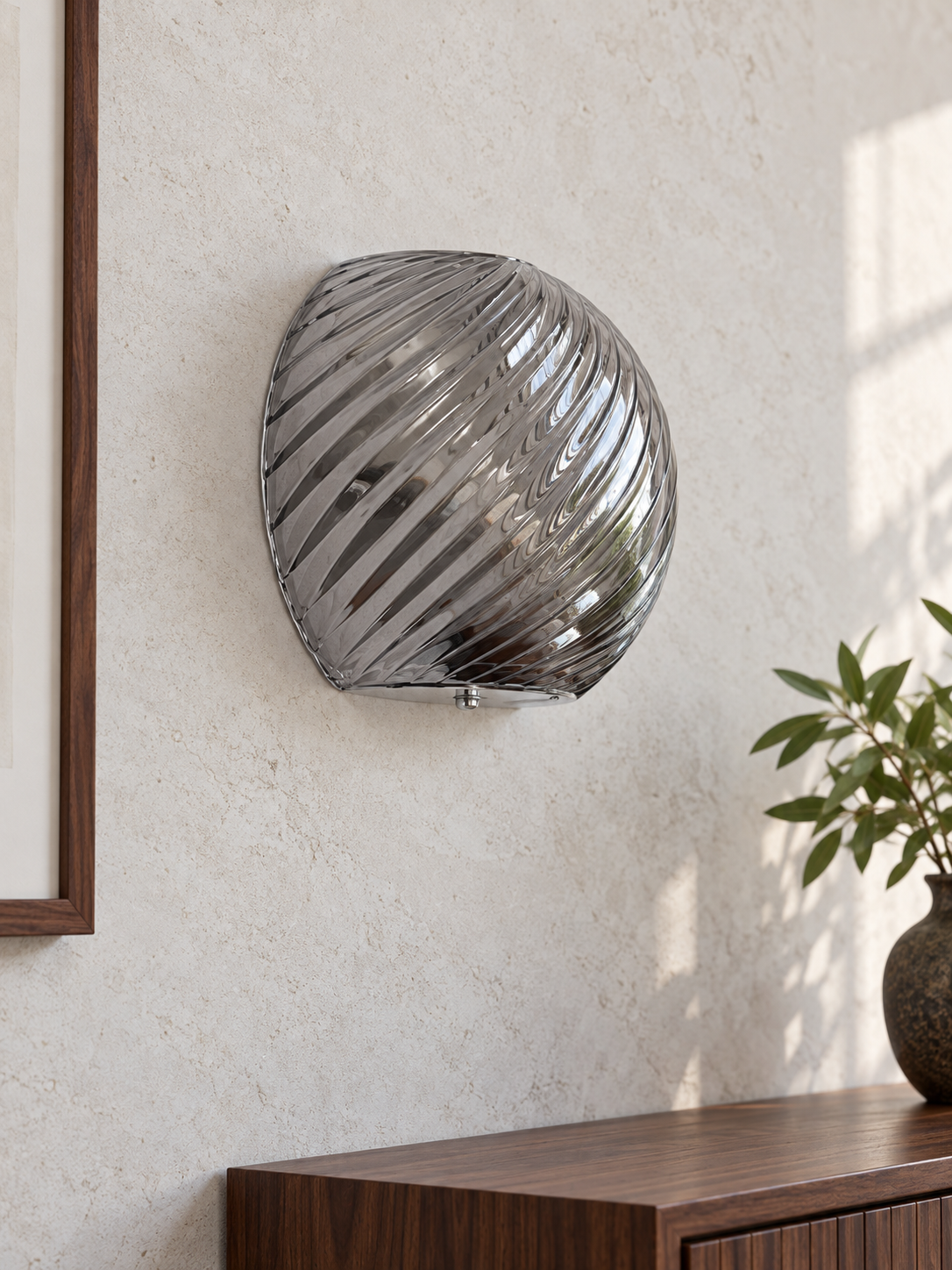Spiral glass wall sconce in Smoke Gray with chrome hardware, shown unlit in daylight