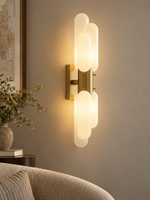 Tiered opal glass wall sconce in Titanium Gold in a quiet reading corner