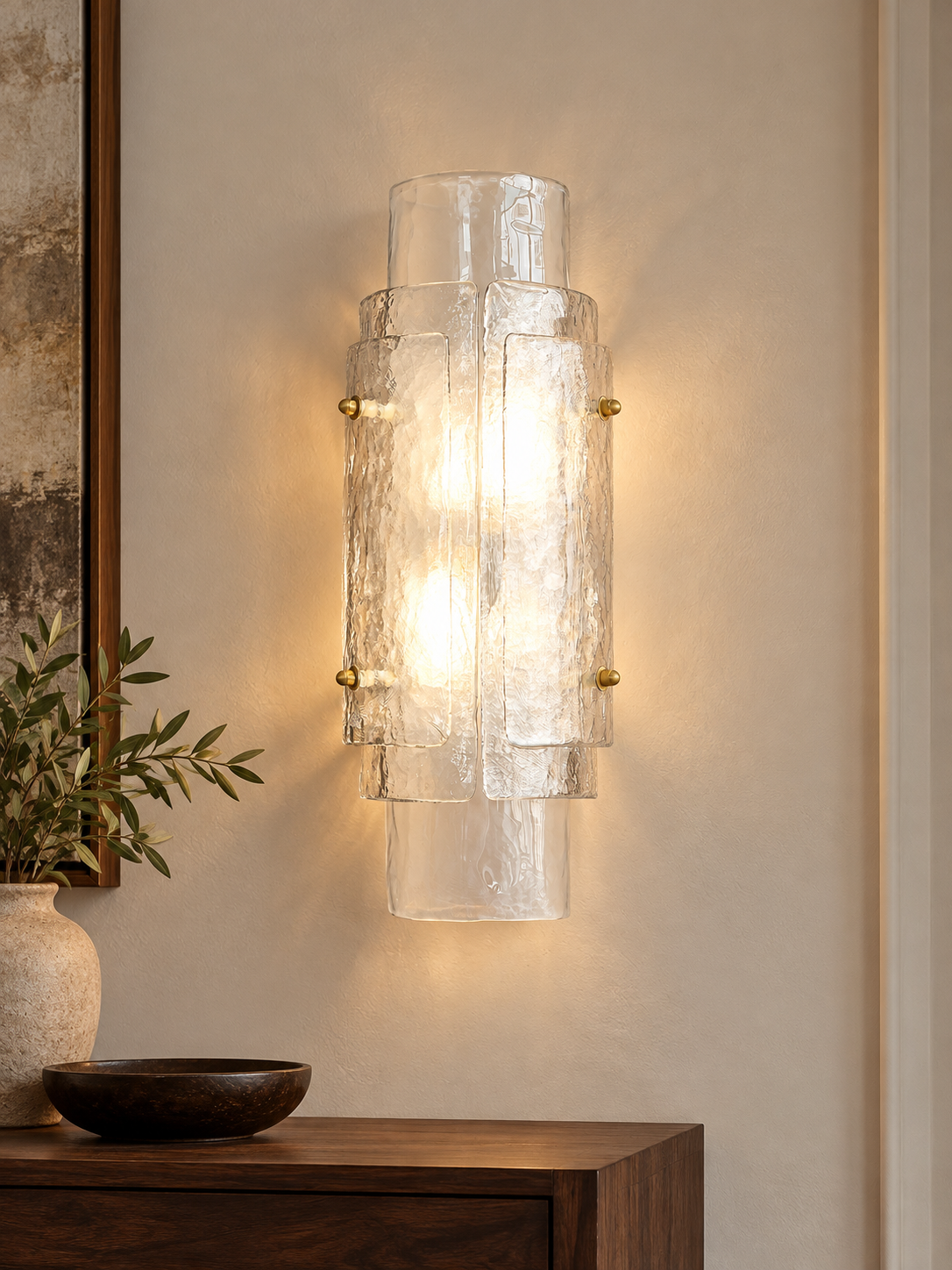 Layered Glass Wall Sconce in Clear glass with copper-tone fittings on an ivory living-room wall
