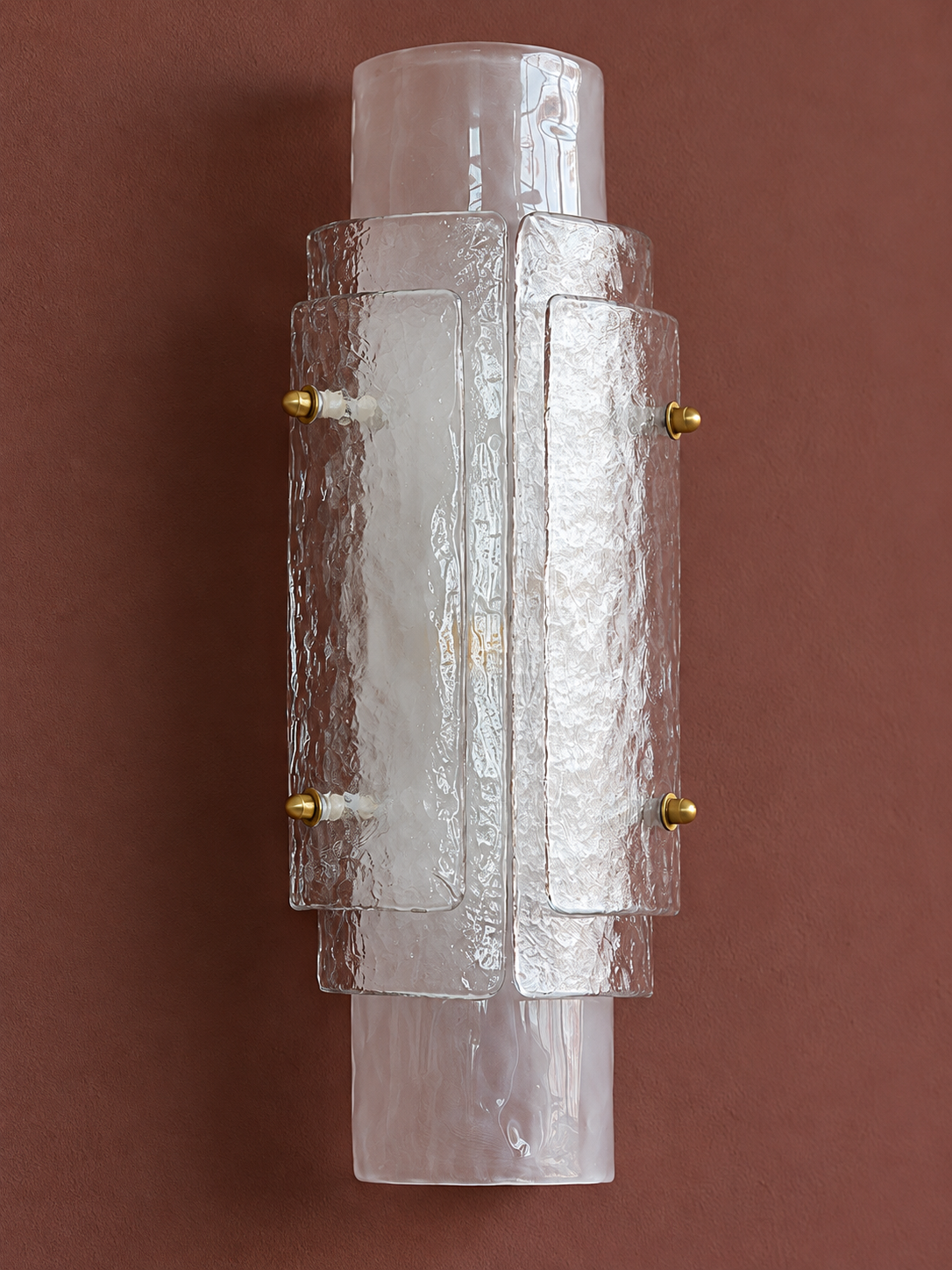 Detail of the Clear wall sconce's overlapping textured glass sheets and copper-tone nuts