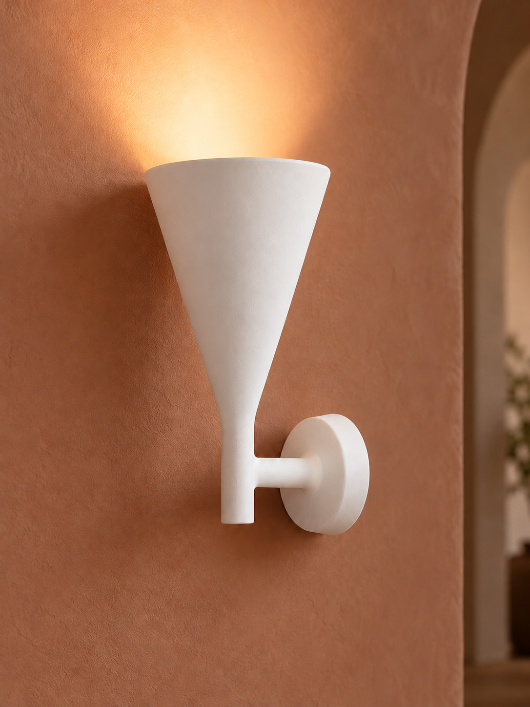 White plaster uplight on terracotta wall