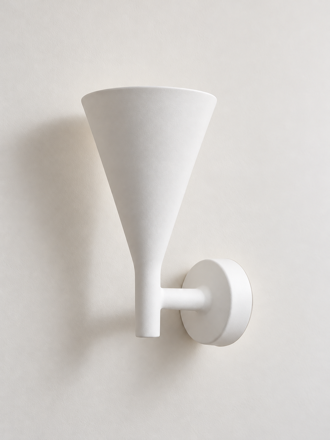 White plaster cone wall sconce on a white background