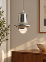 Chrome Bell Glass Pendant illuminated above a walnut sideboard
