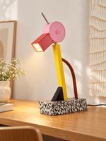 Colorblock Bird LED Table Lamp with pink head and red beak on an oak desk