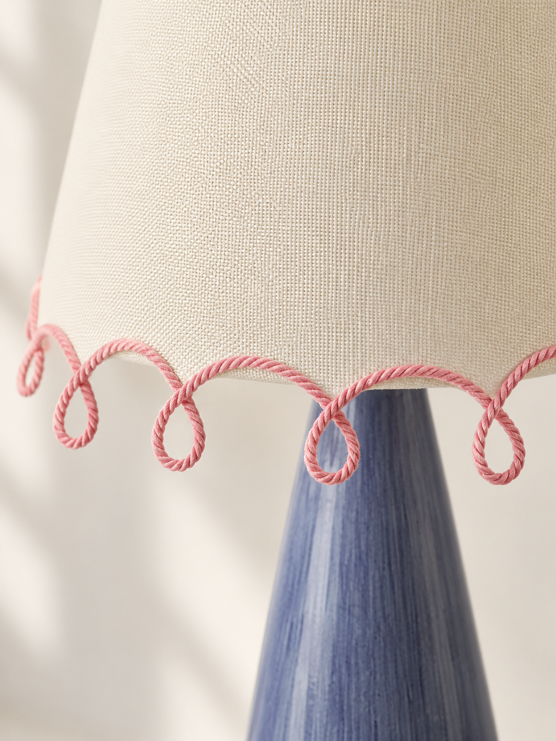 Close view of the ivory fabric weave, pink cord loops and brushed blue stem