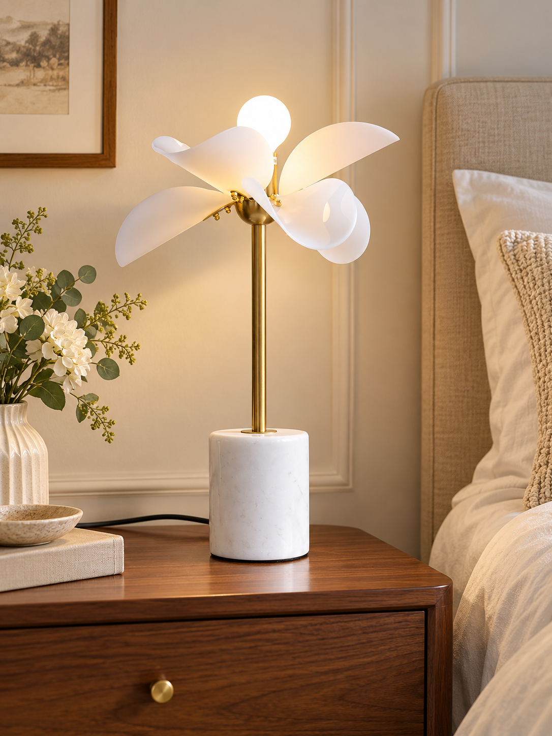 Petal Stem table lamp with white acrylic petals and a copper-finish stem on a walnut bedside table