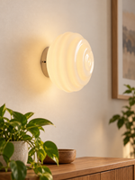 Tiered white glass wall light above a wooden console