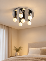 Chrome six-globe flush mount light above a neutral bedroom