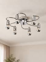 Chrome loop-arm ceiling light with six half-chrome globe bulbs in a neutral living space