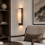 Lifestyle scene: wall sconce beside lounge chair and bookshelf